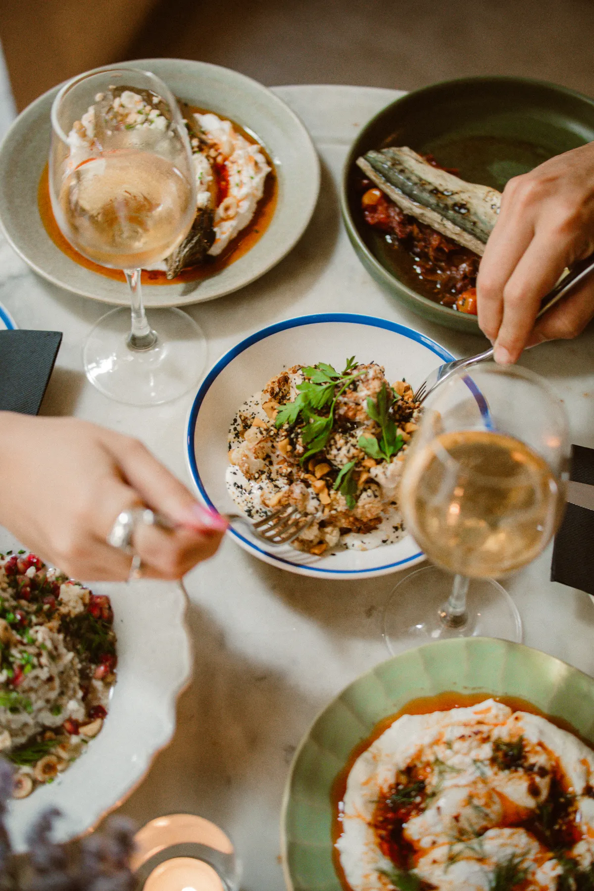 Mans compartint plats de meze al Bistrot Levante